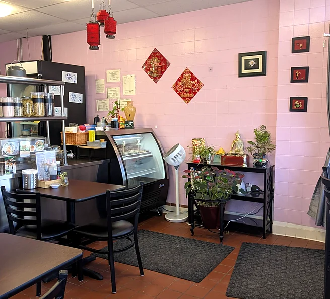 Spice Cove Bistro dining room with tables, plants and the counter