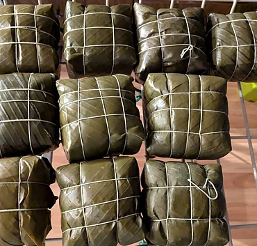 Sticky rice cakes wrapped in banana leaves and tied with string