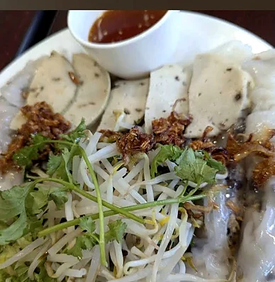 Steamed rice rolls with sliced vegetarian sausage, bean sprouts, herbs and fried shallots
